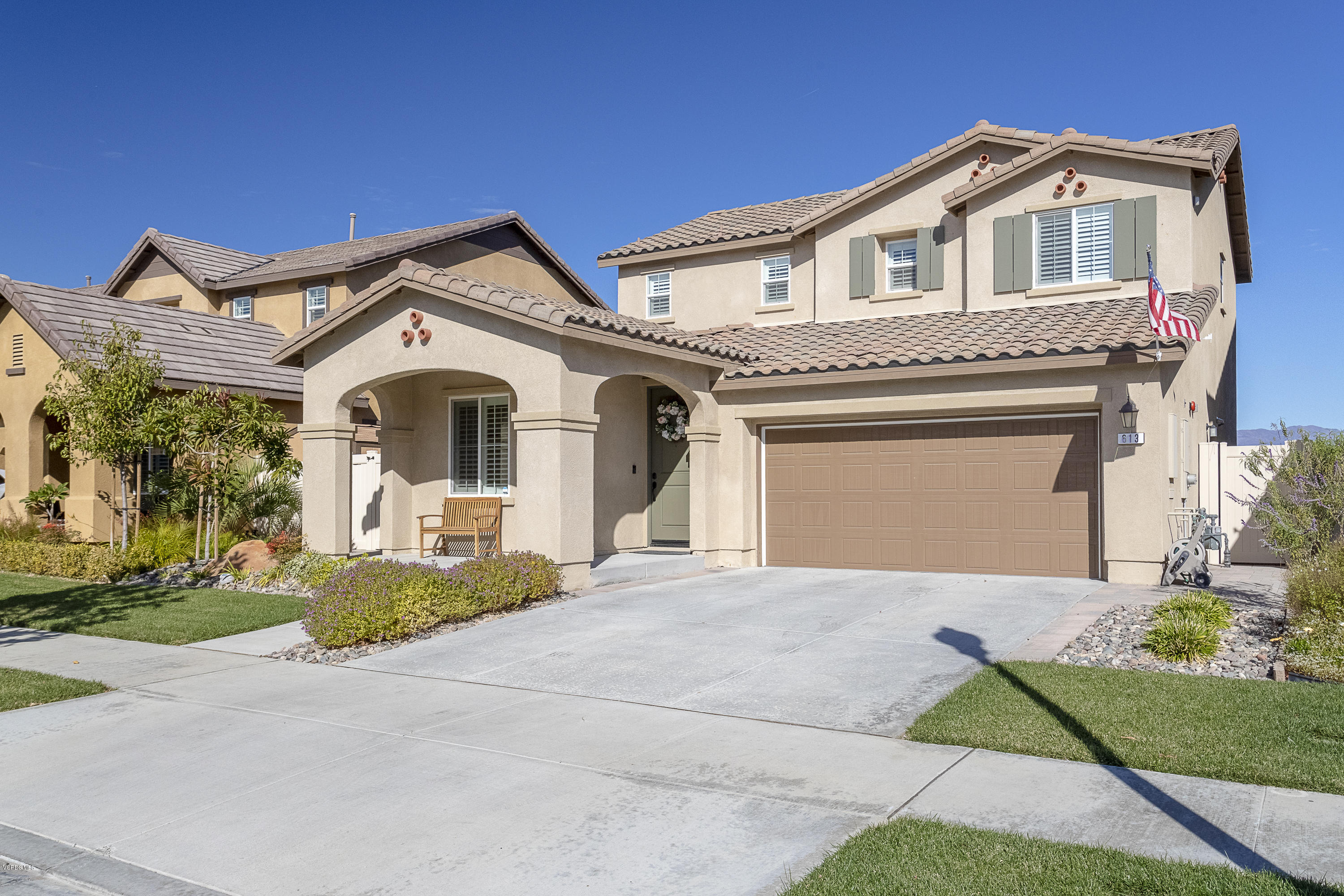 613 Xanadu Way Oxnard, CA 93036 - Photo 2 of 30 a front view of a house with a garden and trees