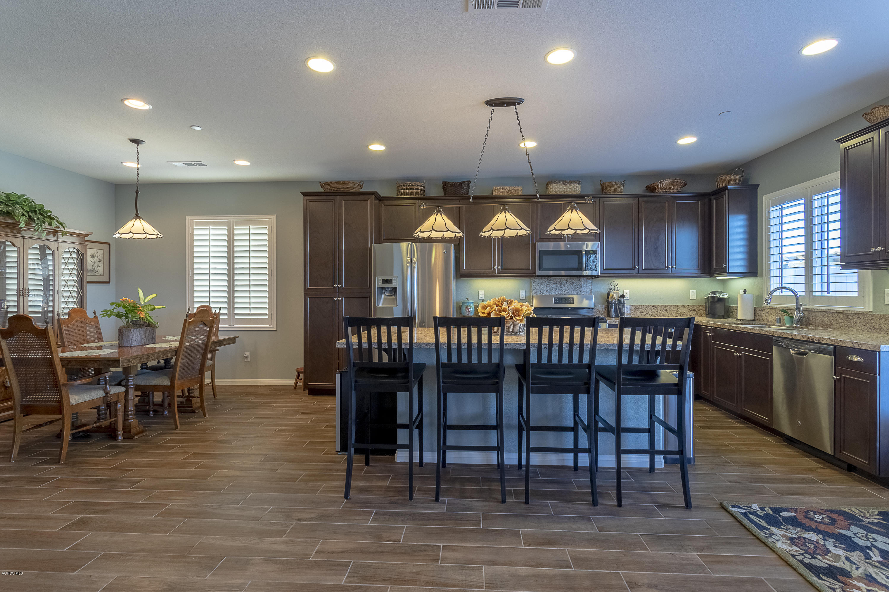 613 Xanadu Way Oxnard, CA 93036 - Photo 7 of 30 a kitchen with lots of wooden furniture and stainless steel appliances