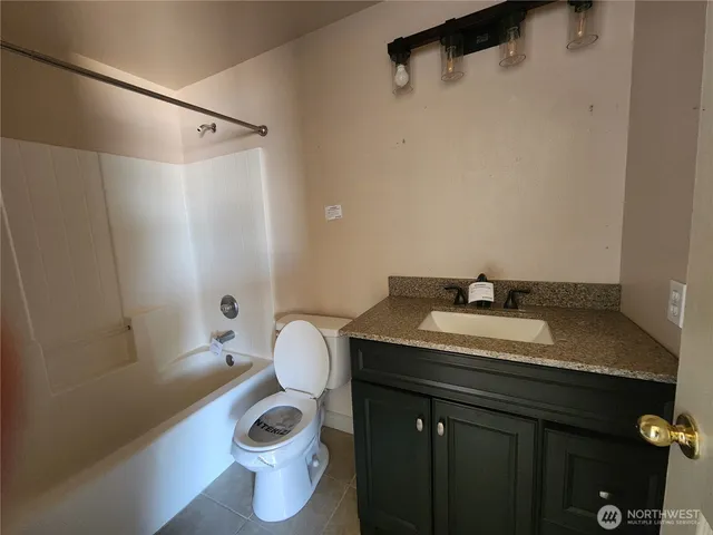 a bathroom with a granite countertop sink a toilet and a mirror