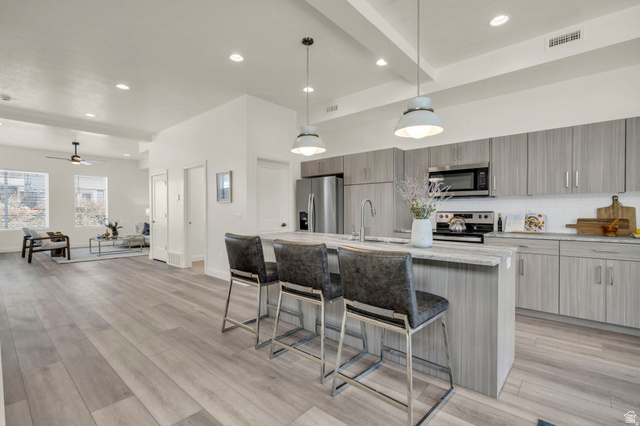4016 South Burch Way Ogden, UT 84405 - Photo 6 of 30 Open-concept kitchen featuring an island with seating, stainless steel appliances, wood-finish cabinetry, and recessed lighting