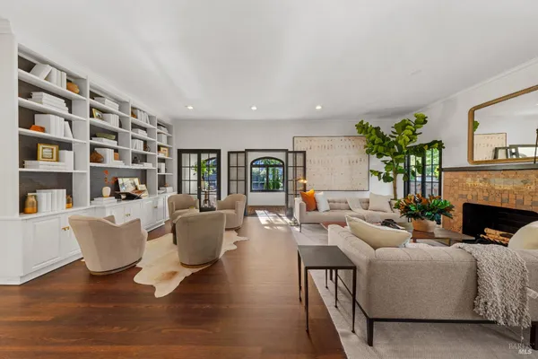a kitchen with stainless steel appliances granite countertop a refrigerator a stove a sink and a dining table with wooden floor