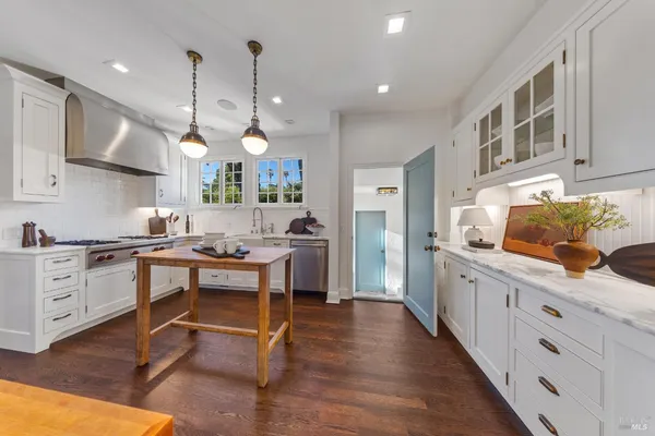 a living room with stainless steel appliances furniture and a large window