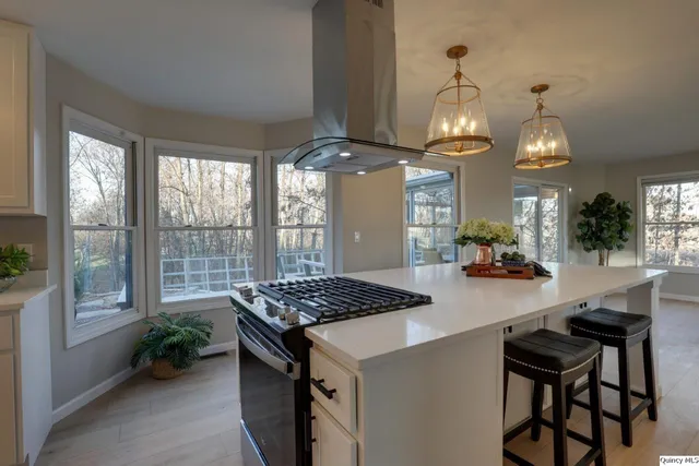 a dining room with wooden floor a chandelier a wooden table and chairs