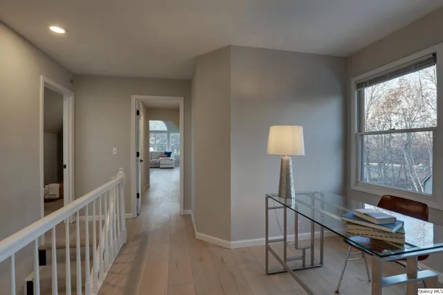 a view of a hallway with workspace and a window