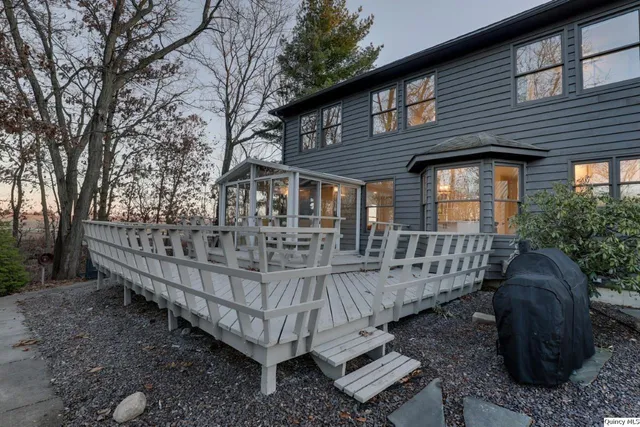 a view of a house with a wooden deck and furniture