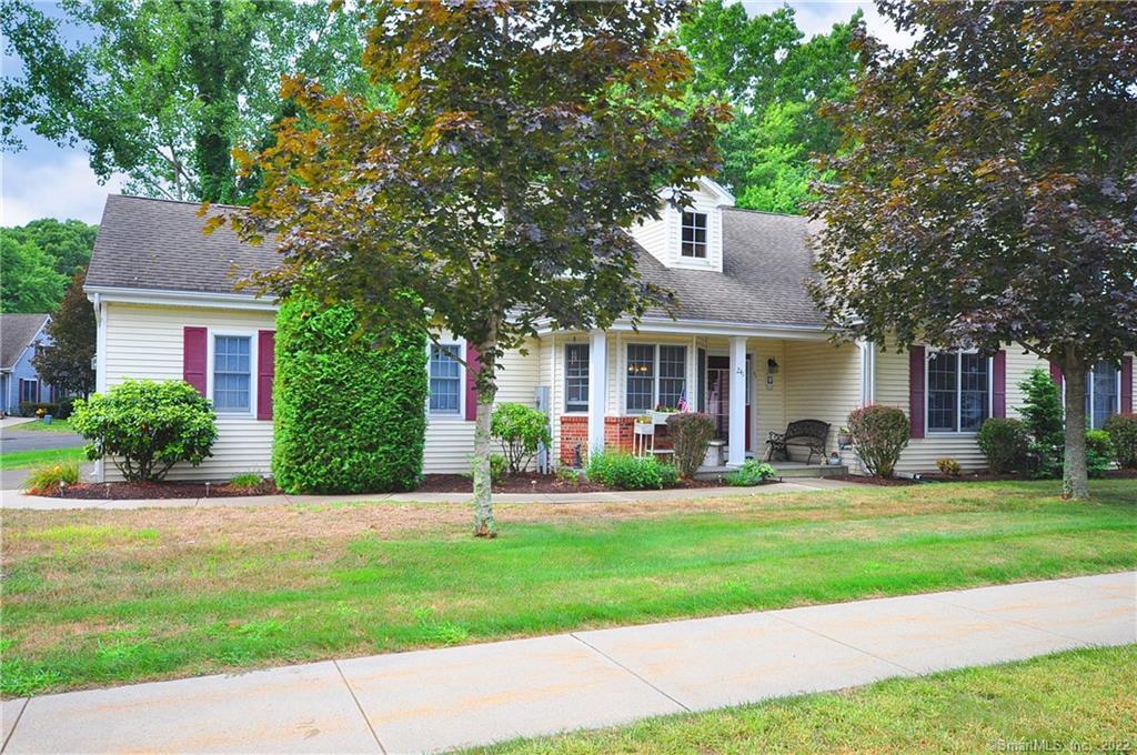 a front view of a house with a yard and trees
