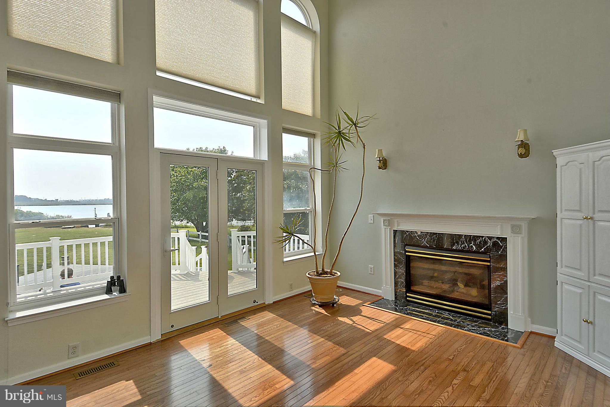 1001 Long Point Road Grasonville, MD 21638 - Photo 6 of 29 a view of an empty room with wooden floor fireplace and a window