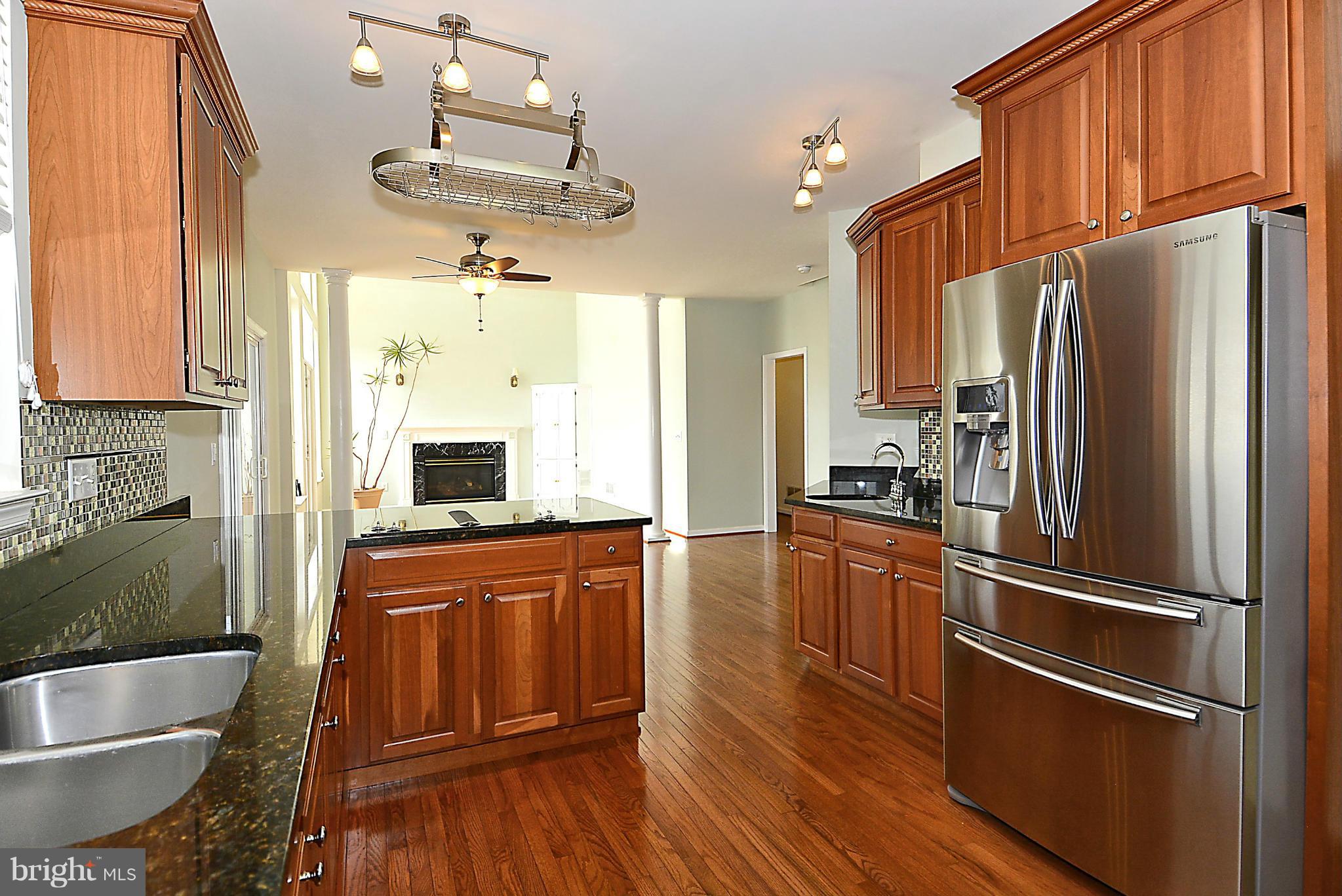 1001 Long Point Road Grasonville, MD 21638 - Photo 9 of 29 a kitchen with granite countertop stainless steel appliances a refrigerator stove and wooden floor