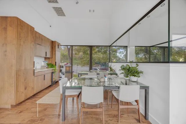 a dining room with furniture a rug and potted plants