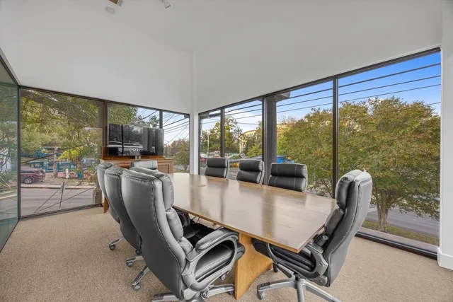 a dining room with furniture and a floor to ceiling window