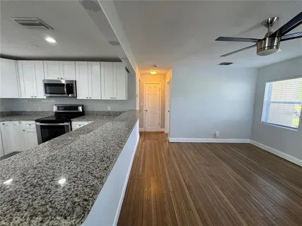 a kitchen with wooden floors and wooden cabinets