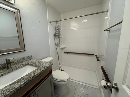 a bathroom with a granite countertop sink toilet and shower