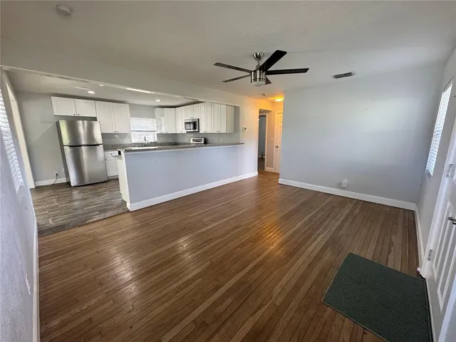 a view of a kitchen with wooden floor and a ceiling fan