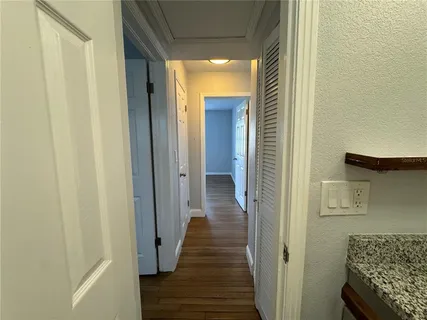 a view of a hallway with wooden floor and staircase