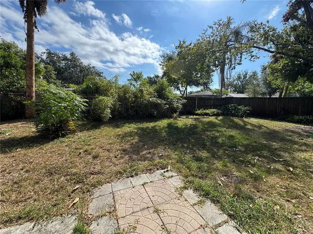 a view of a yard with plants and trees