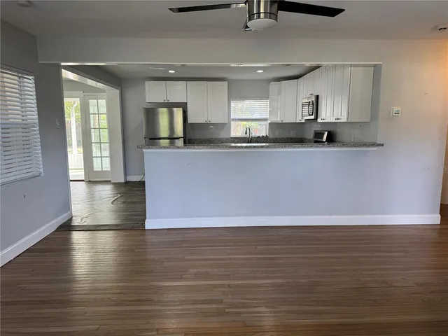 a view of kitchen with microwave and wooden floor