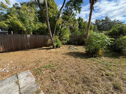 a backyard of a house with a large tree