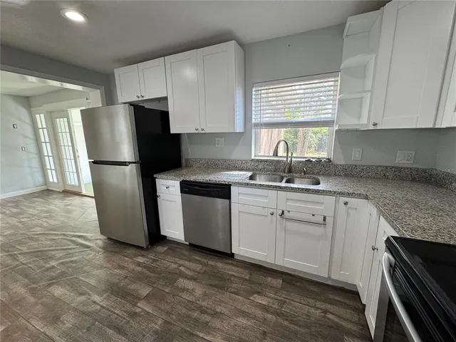 a kitchen with a refrigerator sink and cabinets