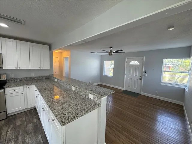 an empty room with window and wooden floor