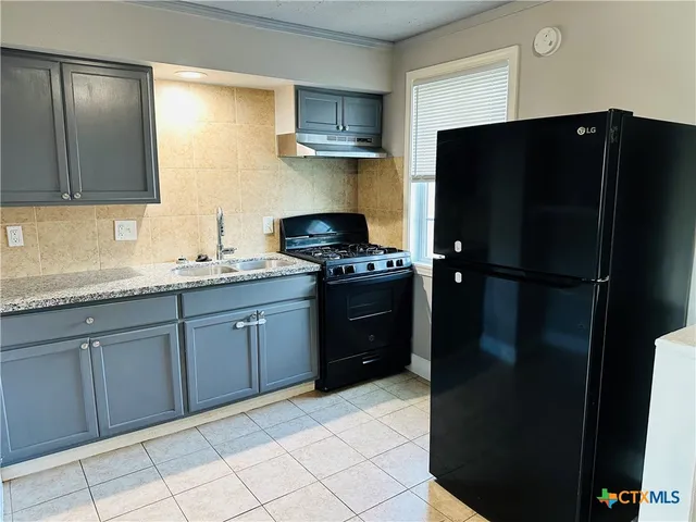 a kitchen with a refrigerator and a sink