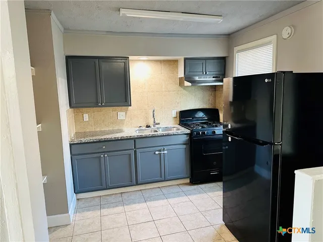 a kitchen with a refrigerator and a sink