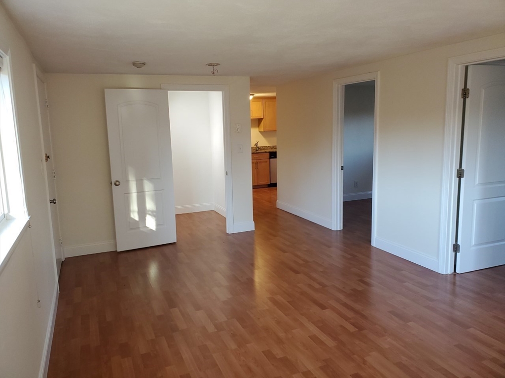 11 Wampus Avenue, Unit 14 Acton, MA 01720 - Photo 3 of 8 a view of an empty room with wooden floor and a window