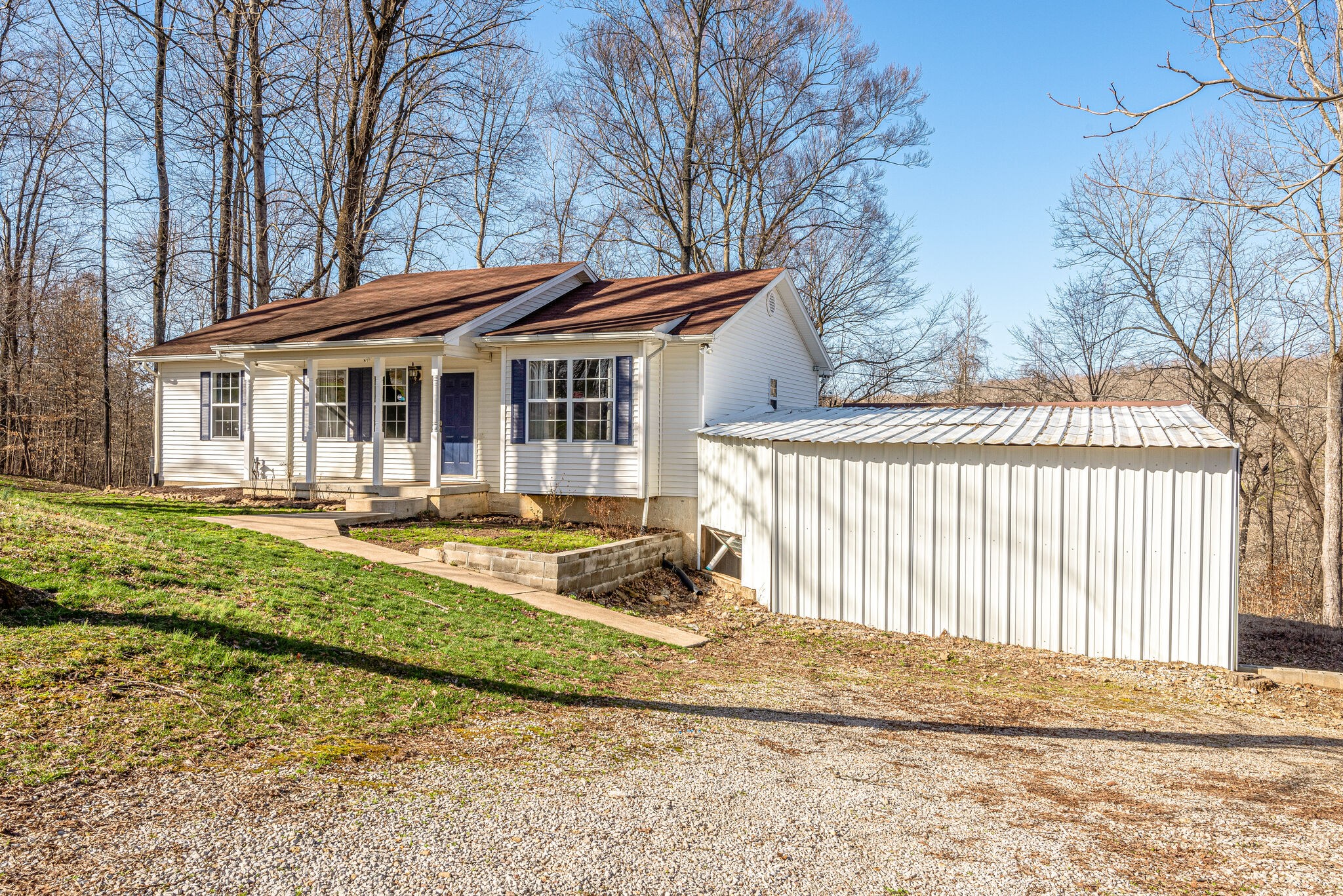 1121 Deer Ridge Road Kingston Springs, TN 37082 - Photo 2 of 27 a view of a white house with a large tree and wooden fence
