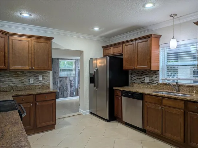 a kitchen with a refrigerator sink and cabinets