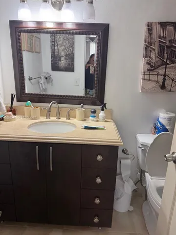 a bathroom with a granite countertop toilet a sink and bathtub