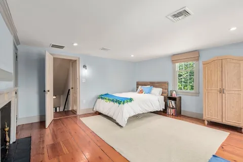 a bedroom with a large bed and a wooden floor