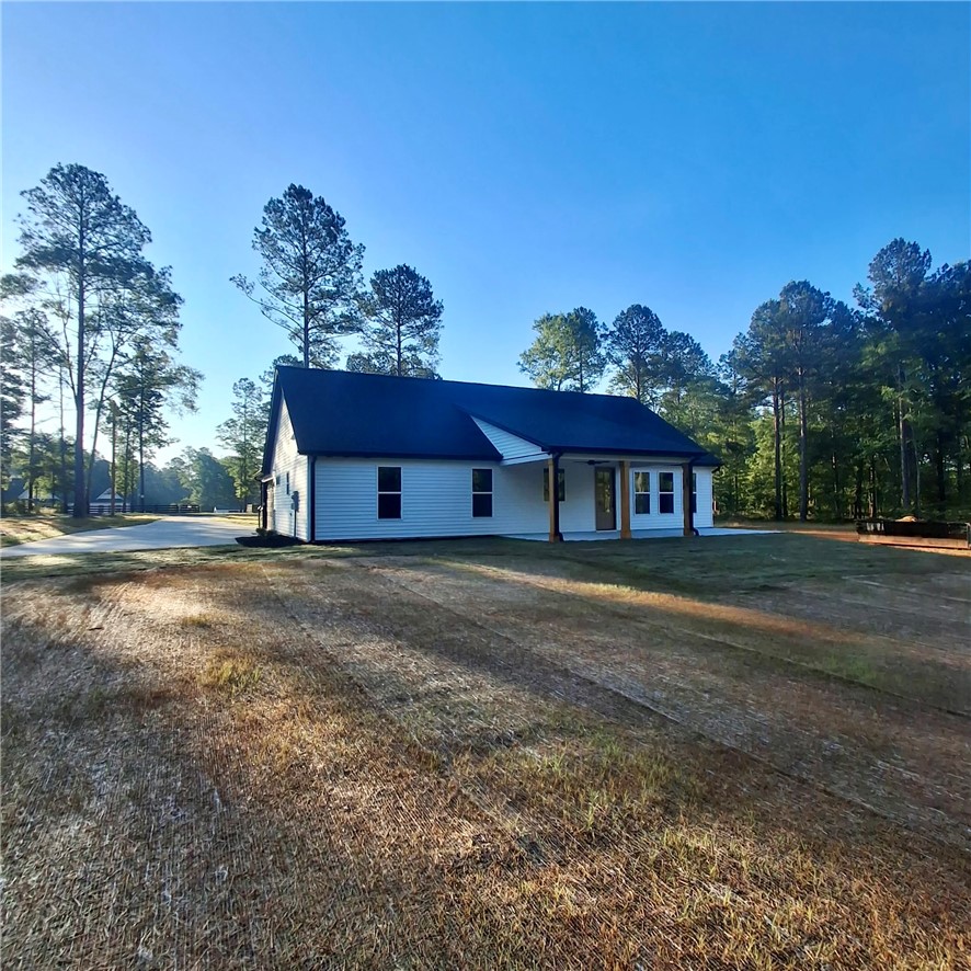 4554 Flat Rock Road Iva, SC 29655 - Photo 4 of 32 A quaint residence nestled among tall pines, featuring a welcoming covered porch.