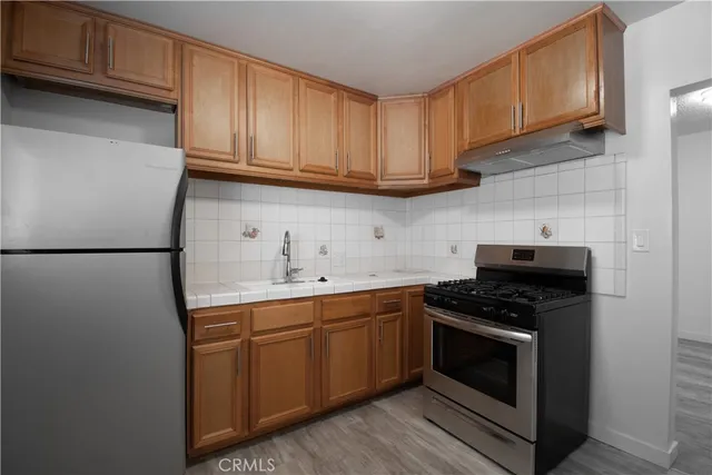 a kitchen with stainless steel appliances granite countertop a stove a sink and a refrigerator