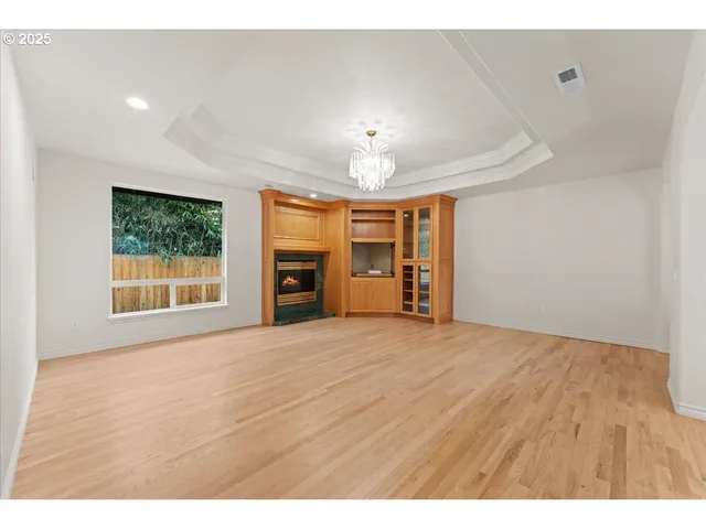 a view of an empty room with a window and fireplace