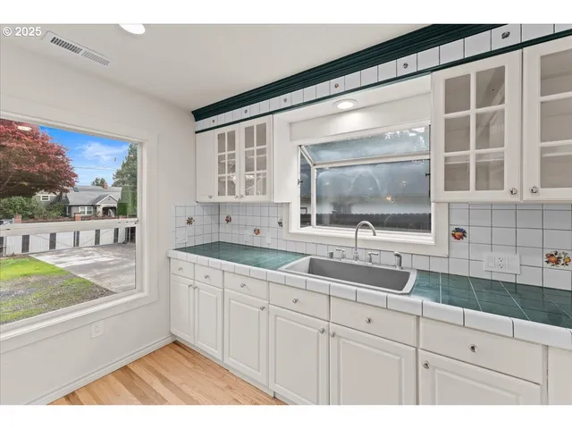 a kitchen with a sink and large mirror