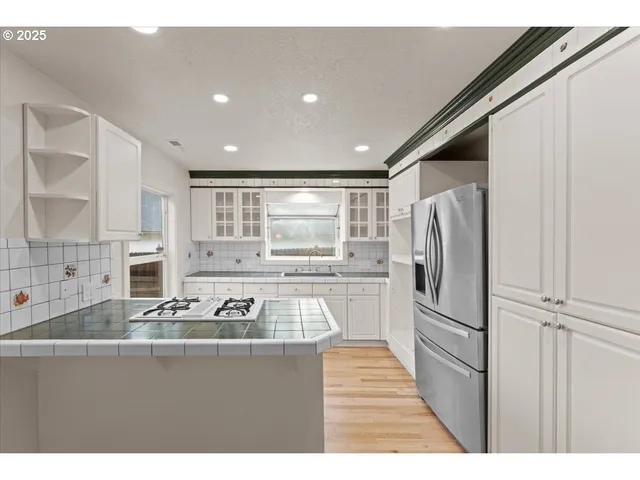 a kitchen with stainless steel appliances granite countertop a refrigerator and a sink