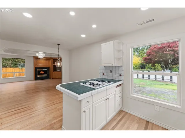 a kitchen that has a stove and a wooden floor