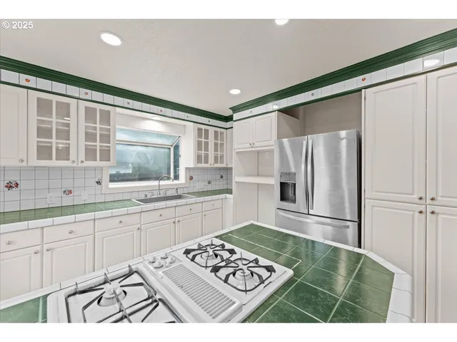 a kitchen with a refrigerator sink and cabinets