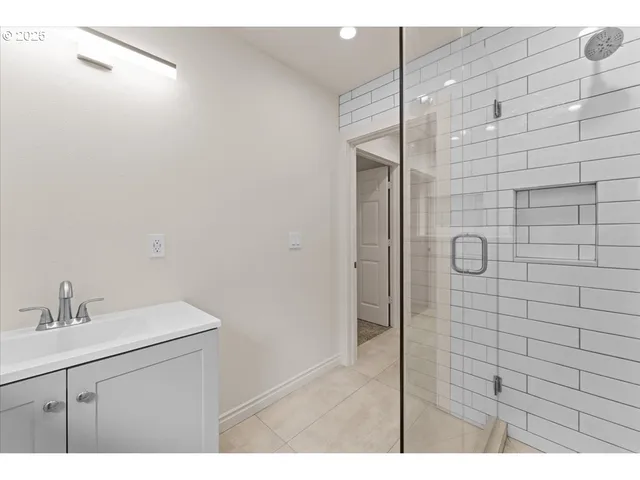 a bathroom with a shower sink and vanity