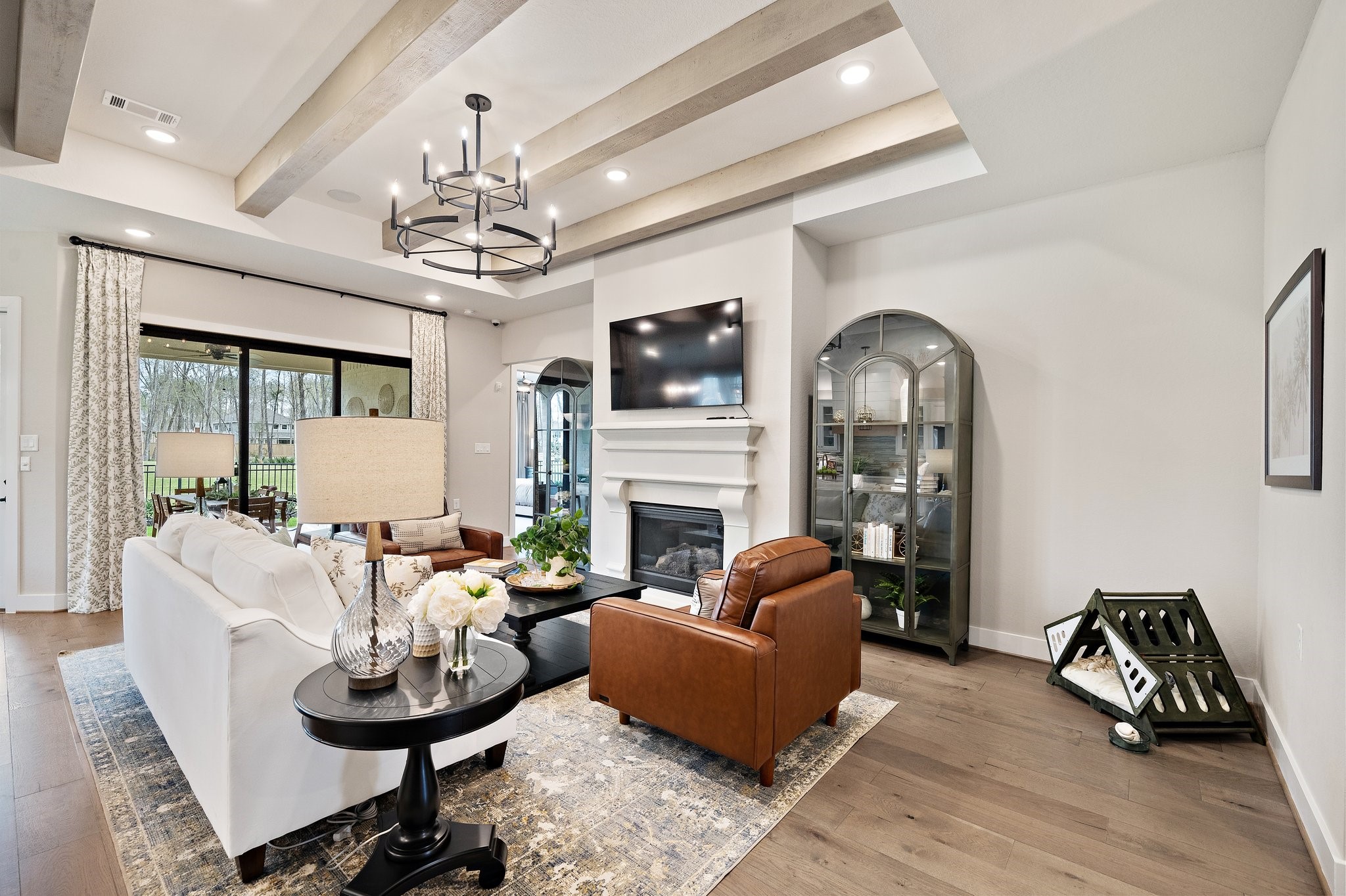 21702 Leaton Circle Porter, TX 77365 - Photo 2 of 36 Light-filled living space with ceiling beams, designer furnishings (included), gas fireplace, and large windows framing serene golf course views.