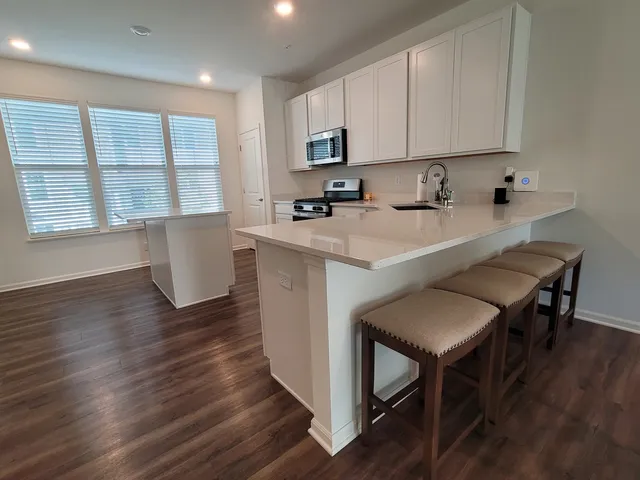 a kitchen with granite countertop wooden floors and stainless steel appliances
