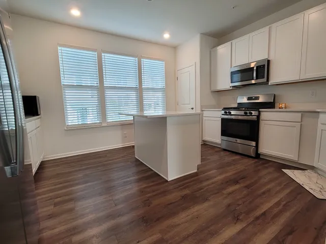 a kitchen with stainless steel appliances a refrigerator sink and cabinets
