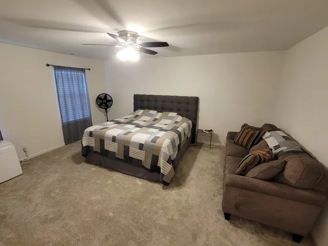 a bedroom with a bed and ceiling fan