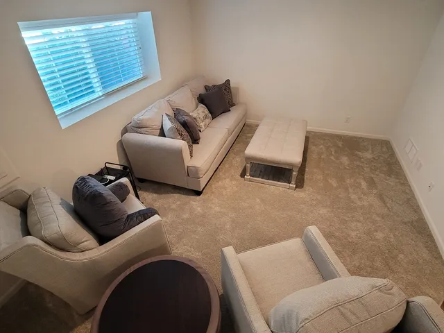 a front view of a multi story residential apartment building with yard and car parked