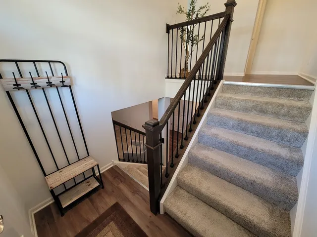 a view of staircase with railing and white walls