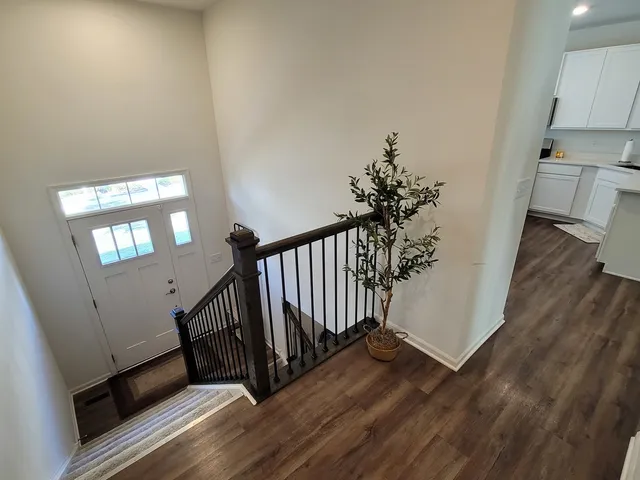 a view of a hallway with wooden floor and stairs