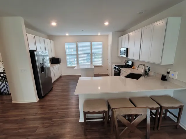 a kitchen with a table chairs refrigerator and microwave