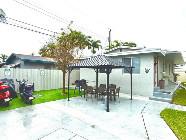 a view of a patio with a table and chairs under an umbrella