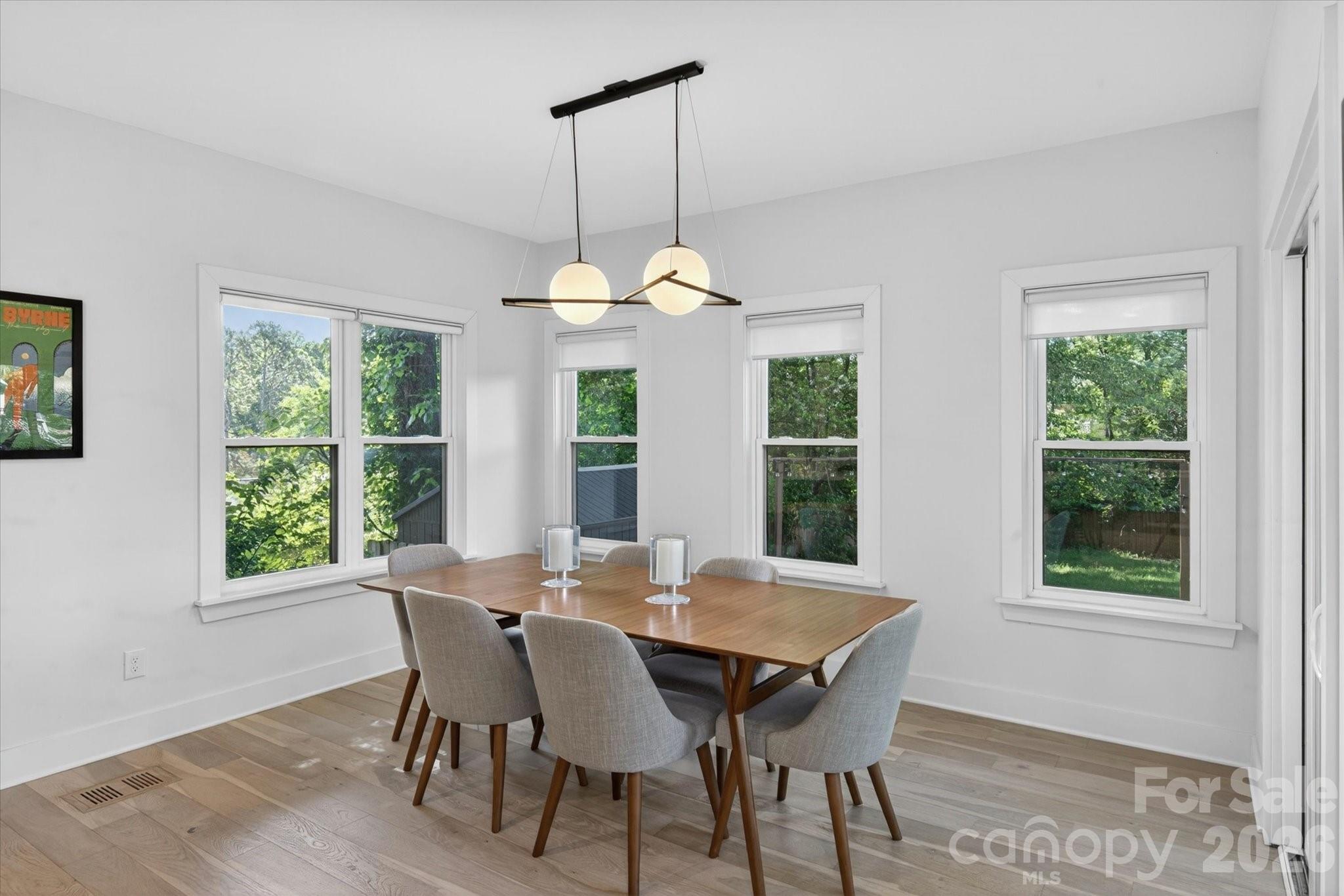 1608 Chippendale Road Charlotte, NC 28205 - Photo 22 of 46 a dining room with furniture a chandelier and wooden floor