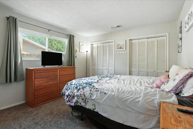 a bedroom with a bed and flat screen tv