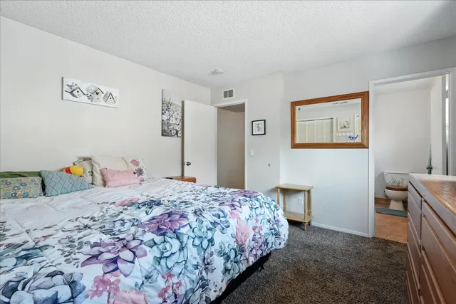a bedroom with a bed and painting on the wall